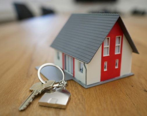 white and red wooden house miniature on brown table